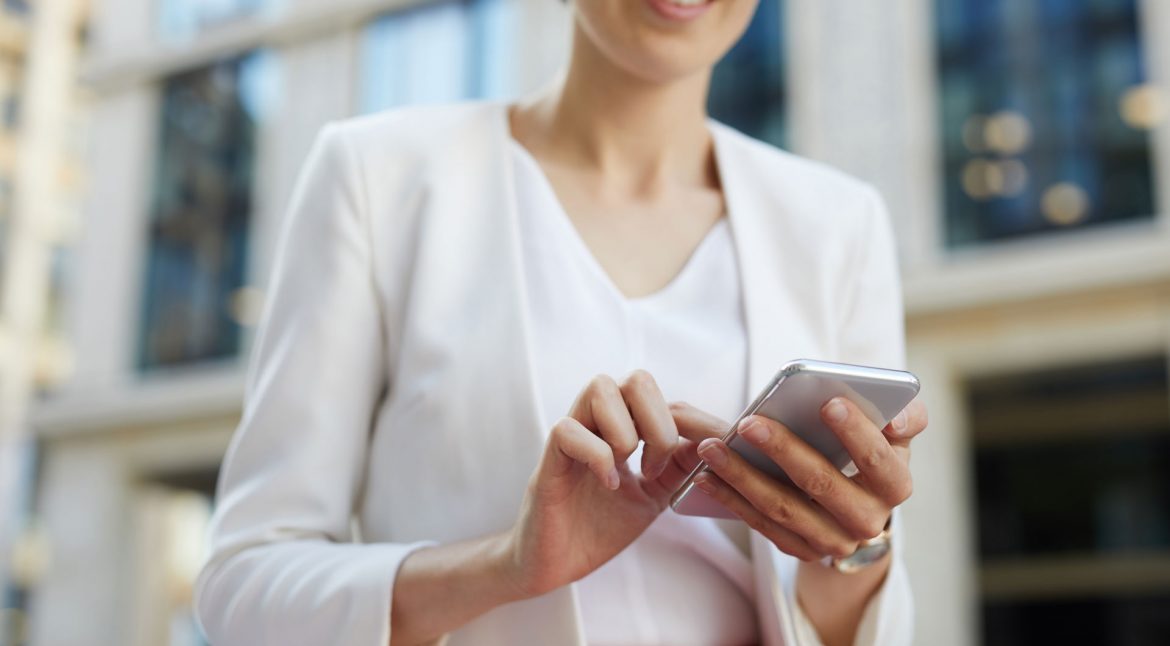 businesswoman-using-smartphone-outdoors-cropped-KAYU7S3