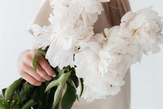 blonde-woman-standing-isolated-holding-flowers-P8B3XEP