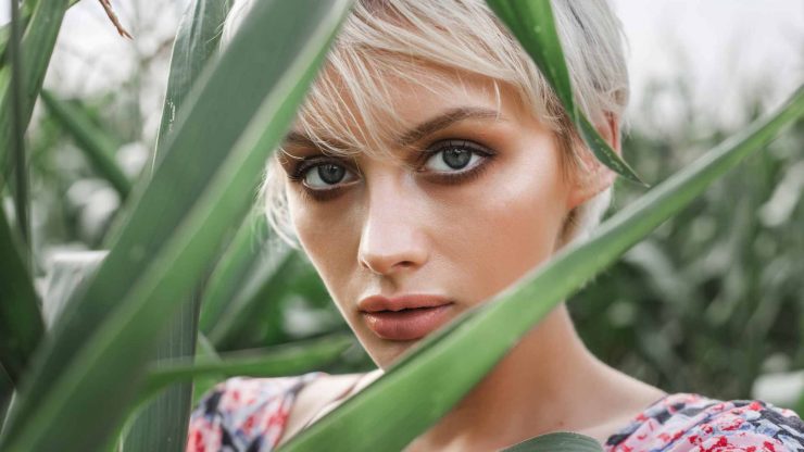 girl-between-green-leaves-in-a-corn-field-PYWBG9G