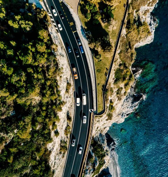 aerial-view-of-road-going-along-the-mountain-and-o-YM4JAH8